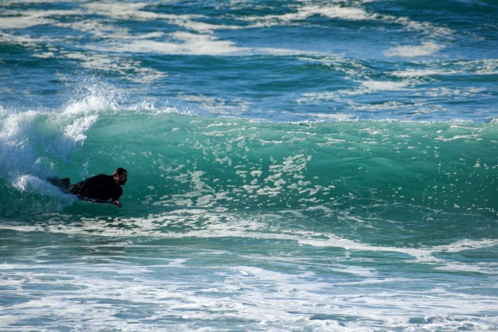 a man riding a wave on top of a surfboard